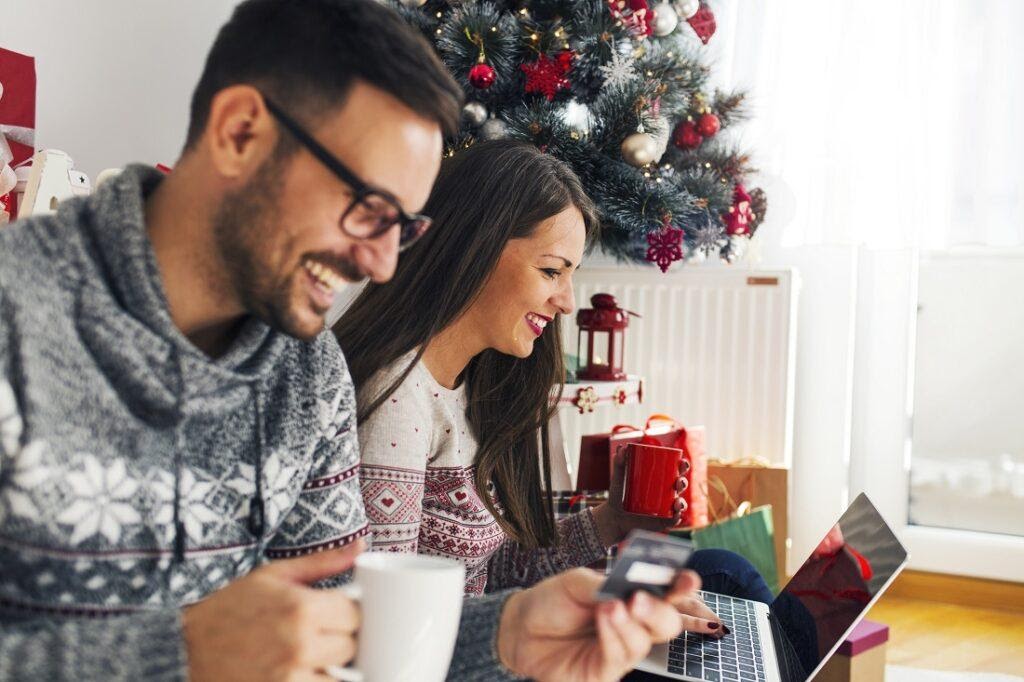 Мъж и жена пазаруващи онлайн коледни подаръци