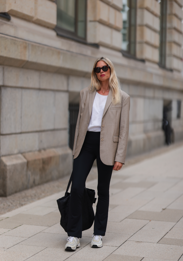 Жена облечена за офис работа със сако, черни панталони, тениска и спортни обувки