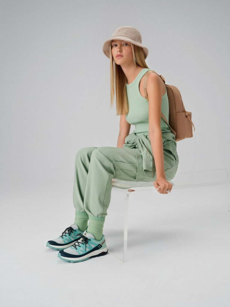 Модел, облечен в стил streetwear: бежова шапка adidas и обувки Salomon
